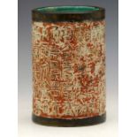 Chinese cylindrical brush pot of red ground moulded with archaic calligraphy, height 16cm