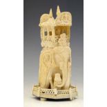 Indian ivory ornate model of an elephant carrying a howdah whilst trampling over a tiger, early 20th