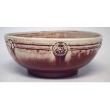 Ruskin high fired bowl   with moulded floral bosses, decorated with a red and purple mottled