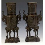 Pair of Japanese patinated bronze vases raised on mask capped legs and quatrefoil base, height