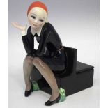 Lenci Nella Figural box, modelled sat with her book on a box settle with cover and frog finial,
