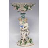 German porcelain table centrepiece,   modelled with a mother and child sat on a tree stump beneath a