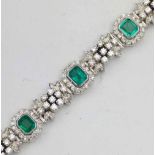 Emerald and diamond bracelet of eight emerald cut stones interspersed by hinged floral links of