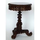 Burmese hardwood tripod table, the foliage circular tip-top on a an ornate column and tri-point