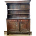 Oak dresser, 18th century, the boarded plate rack back with a canopy over two short drawers and