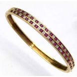 375 gold ruby and diamond bangle, the hinged half hoop set with two channels of alternating