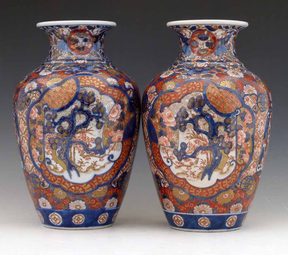 Pair of Japanese Imari vases decorated in the typical palette with panels of foliage, height 30cm.