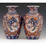 Pair of Japanese Imari vases decorated in the typical palette with panels of foliage, height 30cm.