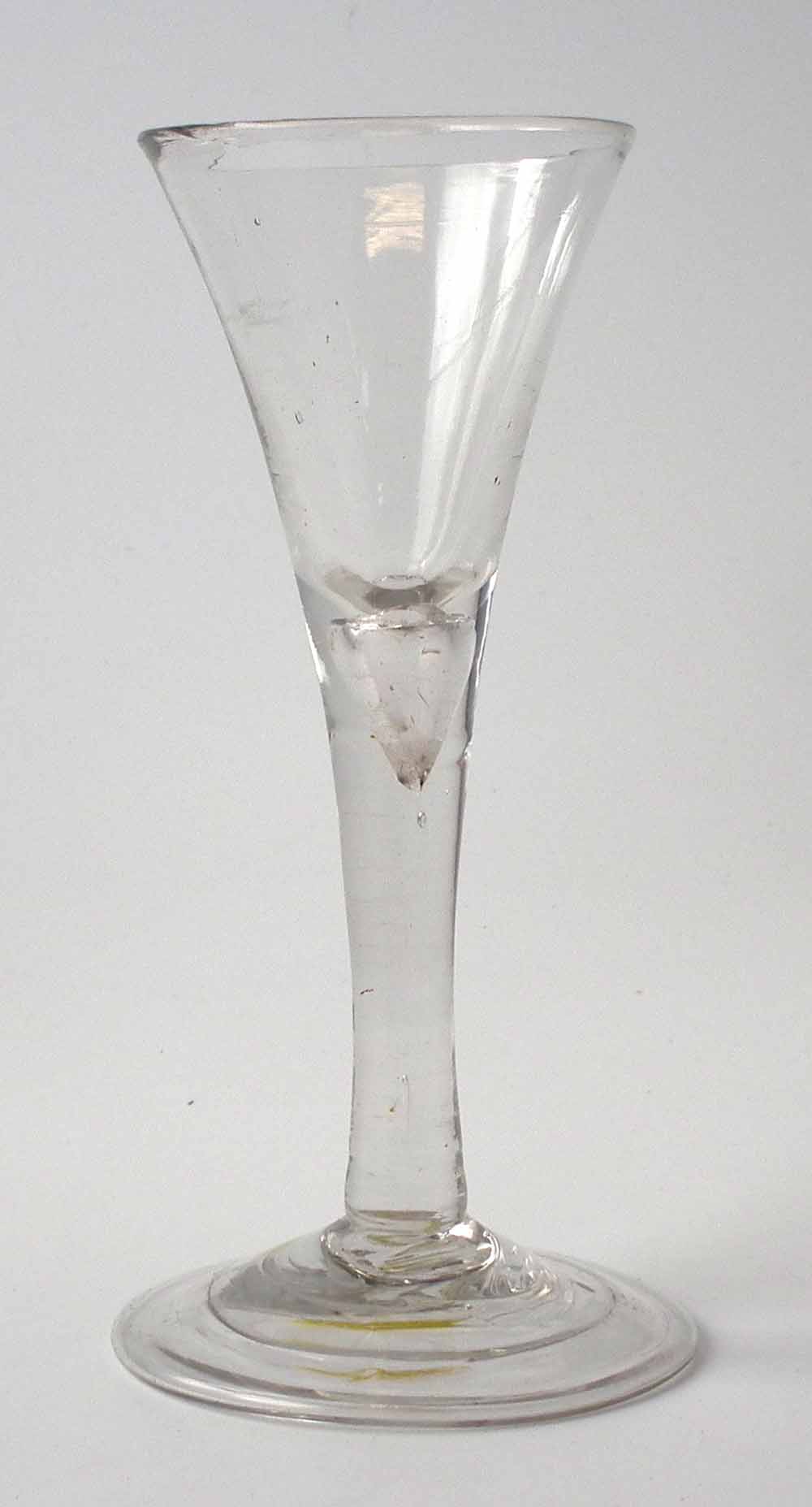 Mid-18th century wine glass with flaring bowl plain stem with tear inclusion, and folded foot,
