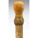 Whale bone walking stick with a carved rope twist hilt and marine ivory knob, overall length 93cm.