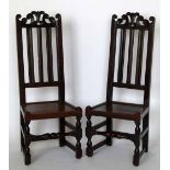 Pair of oak backstools, late 17th century, the carved scroll top rail over vertical splats, panelled