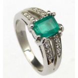 Emerald ring the stone on bifurcated melee diamond shoulders, the white shank stamped 750, ring size