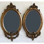 Pair of oval gilt framed girandole wall mirrors with bevelled plates and three scrolling candle