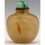 Chalcedony snuff bottle of pale orange hue streaked with two darker clouds, green stone cap, overall
