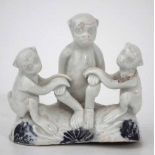 Japanese Hirado porcelain monkey group, modelled as an adult and two young sat on a rocky base, 19th