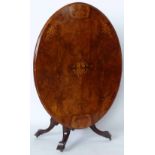 Late Victorian inlaid walnut centre table, the oval tip top on four carved legs, length 133cm.