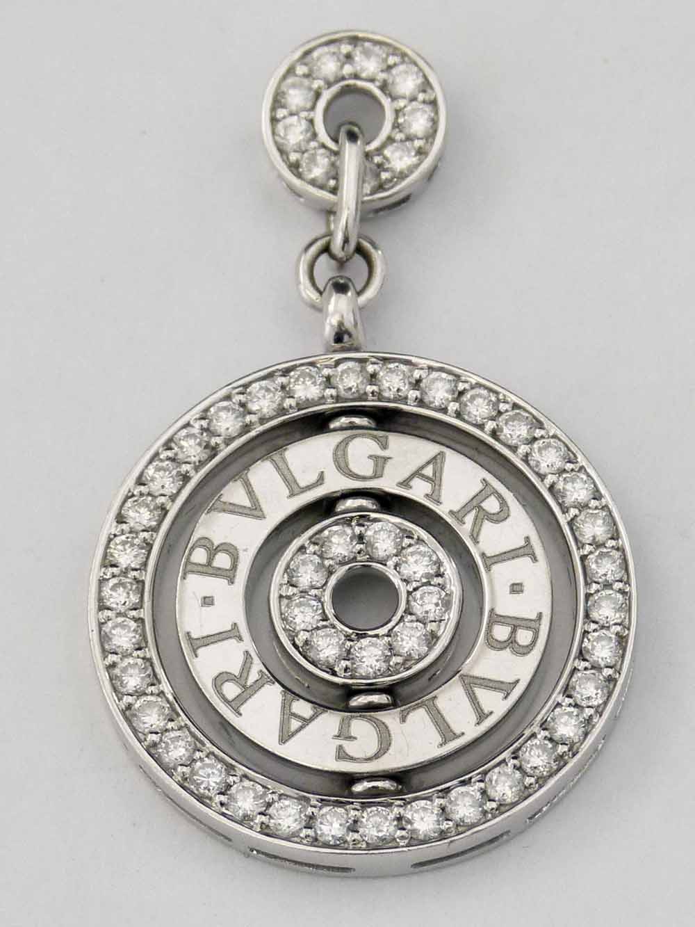 Target pendant set with concentric bands of diamonds and a central rotating ring engraved "