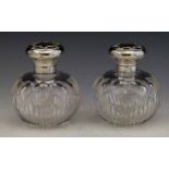 Two cut glass globular scent bottles with silver tops, London 1912,  height 11cm.