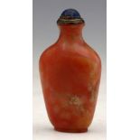 Stained red marbled chalcedony snuff bottle, the flattened body with a blued stone and silver cap,