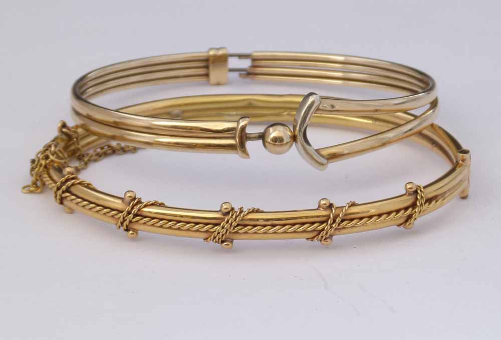 18ct gold hinged bangle, 10.9g, and a 9ct bangle with sprung metal core (2).