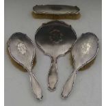 Four-piece silver backed dressing table set of three brushes and a mirror, Birmingham 1945/6.