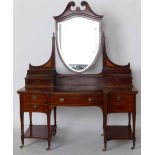 Edwardian inlaid mahogany kneehole dressing table with a shield shaped swing mirror, length 152cm.