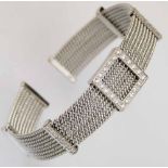 White gold (750) mesh bangle set at intervals with channels of brilliant diamonds, gross weight 35.