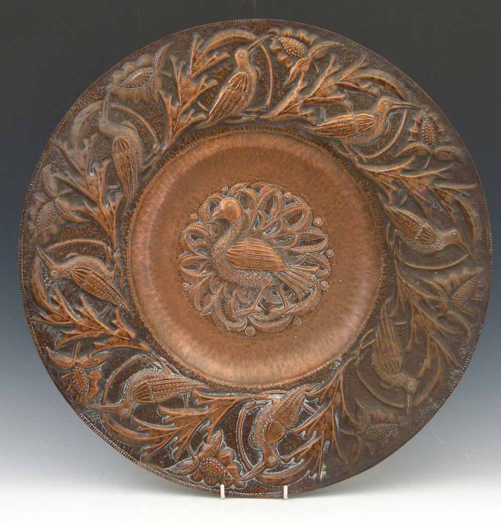 John Pearson, 1892, (fl.1885 - 1910) an embossed copper charger, the well decorated with a