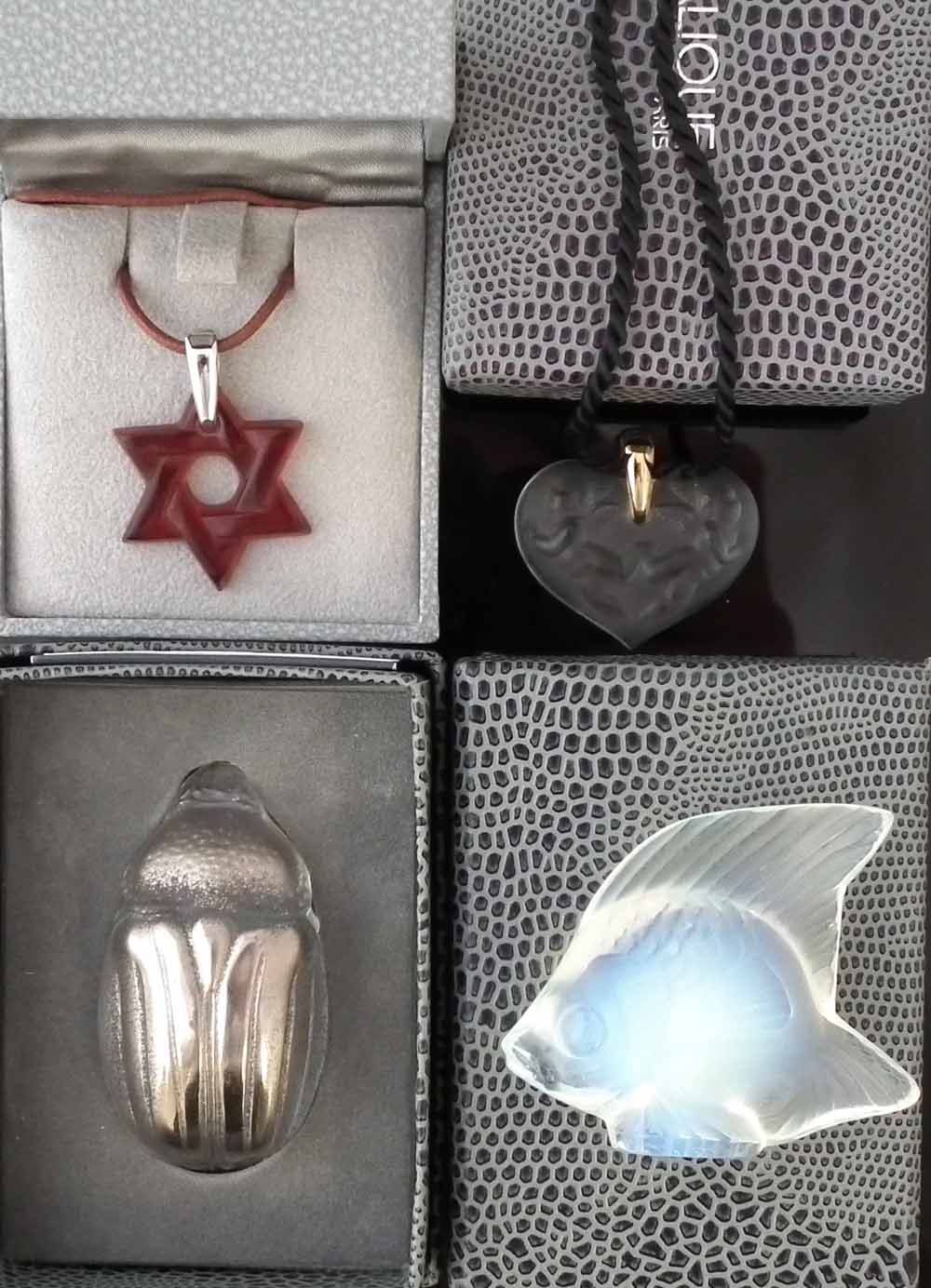 Two Lalique boxed necklaces, modelled as a Star of David, the other with two cherubs, also two other