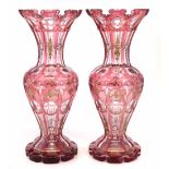 Pair of mid 19th century Bohemian glass vases, with red cut through panels, decorated with gilt