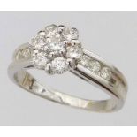 White gold cluster diamond ring on channel set shoulders, ring size T, gross weight 6.0g.