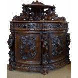 Continental heavily carved oak floor standing quadrant corner cupboard decorated in relief with