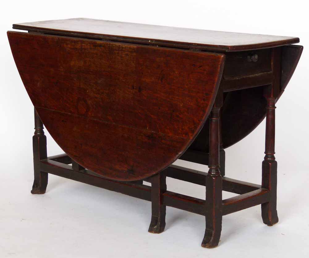 Oak gate-leg table circa 1700, the oval top over a single end drawer on block and turned legs and