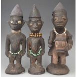 Pair of Yoruba Ibeji figures, and one other carved riding a horse (3) the largest figure measures