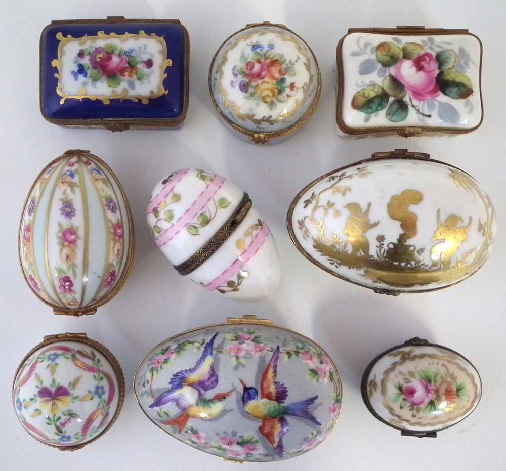 Nine Limoges porcelain boxes, including five egg shaped boxes, painted with floral patterns and