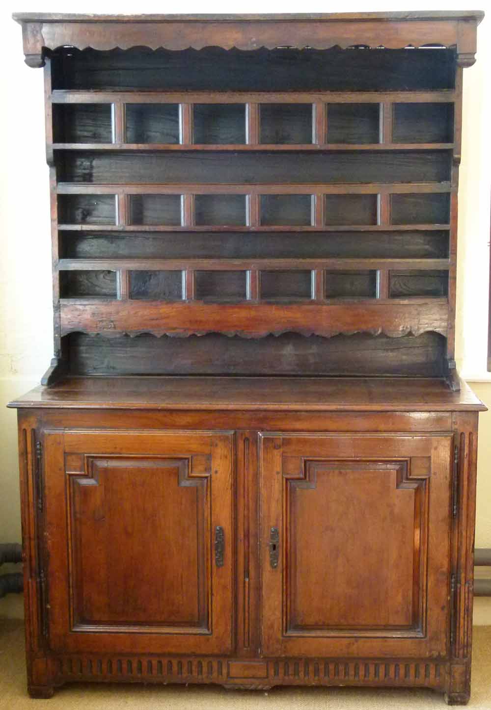 Fruitwood and chestnut dresser, the boarded rack over two panelled doors, width 138cm.