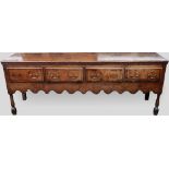 Oak dresser base, partly 18th century, the plank top banded in mahogany over four short drawers (