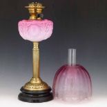 Victorian table oil lamp the moulded pink glass reservoir on a brass reeded column, height 48cm,
