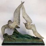 Patinated and painted bronze study of two shearwaters above waves, after J Loriot, on black marble