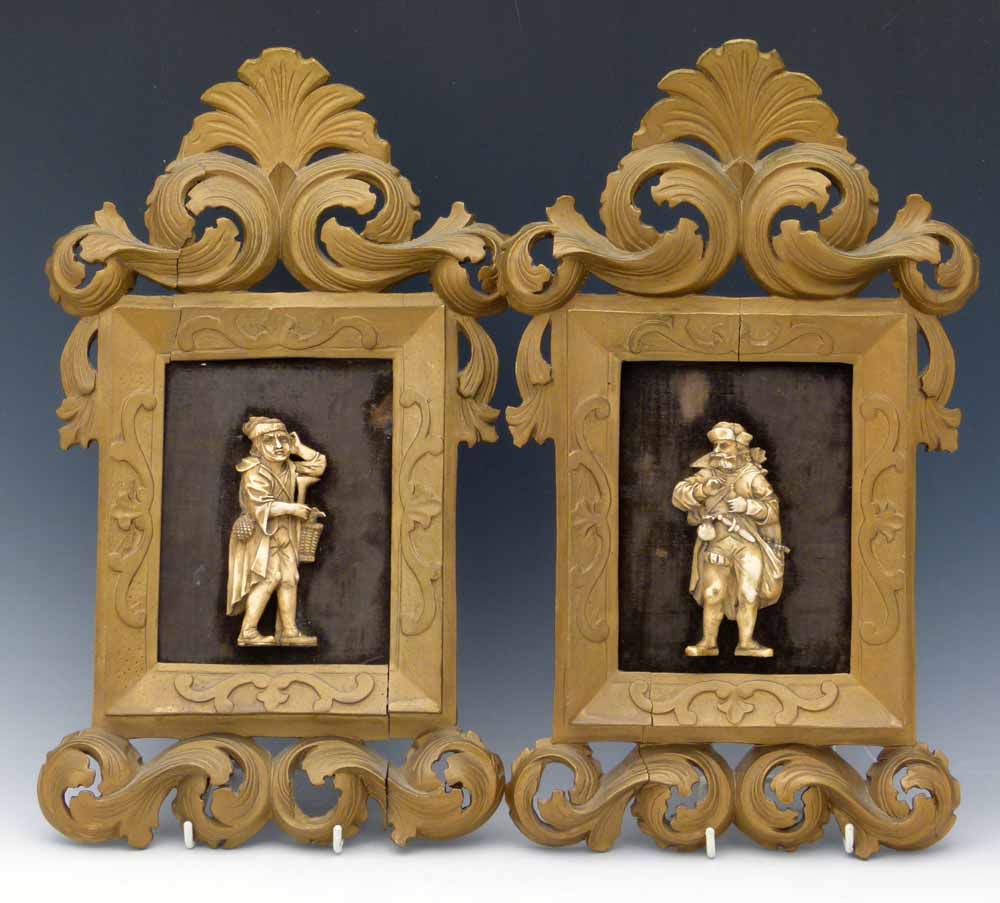 Pair of carved ivory flat back figures of medieval characters in carved wood rococo style frames,