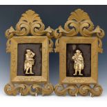 Pair of carved ivory flat back figures of medieval characters in carved wood rococo style frames,