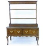 Small oak dresser, the open plate rack back on a base of two short drawers and shaped legs, length