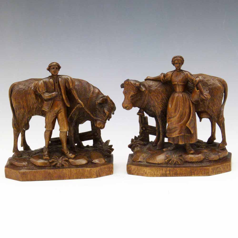 Pair Low Countries carved walnut figures of a dairy farmer and wife, initialled EB, height 13cm.