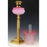 Victorian table oil lamp with a moulded pink glass reservoir and reeded brass stem, height 55cm ,