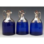 Set of three Bristol blue spirit decanters, the white metal necks engraved "Rum", "Brandy" and "