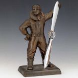 Patinated table lighter of an airman holding a chromed propeller, height 27cm.