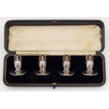 Set of four cast silver menu or place holders in the form of owls with glass bead eyes, by
