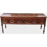 Oak dresser base or sideboard, the plank top over three short drawers with geometric mouldings and