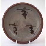 Shoji Hamada (1894 -1978) studio pottery dish, painted with script on a green glaze, 17cm diameter