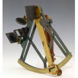 Simple brass sextant with a green lacquered frame, two shade glasses and a sighting hole, the